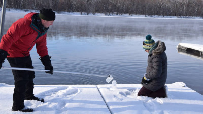 2 scientist collecting ice on Mississippi to sample